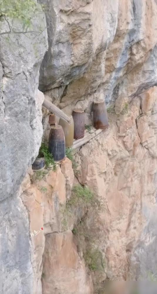 这里是陕西秦岭深山悬崖绝壁，崖壁平台摆放五口古缸，旁悬旧铃铛。这处古迹最让人