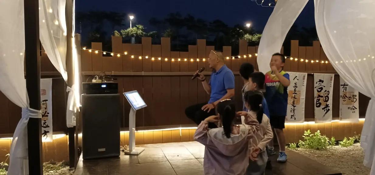 这张照片是在一处民宿夜间拍摄的，爷爷坐在昏暗KTV里面，敞开心扉，放声歌唱，几个