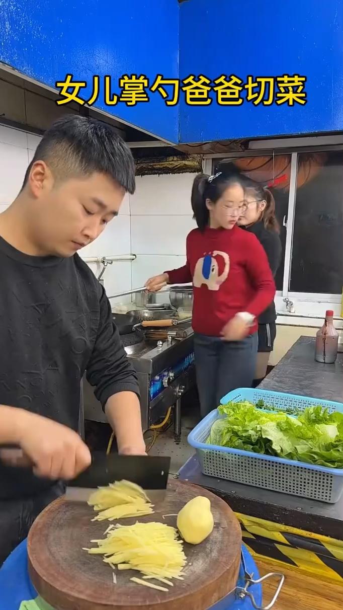 女儿掌勺爸爸切菜。
