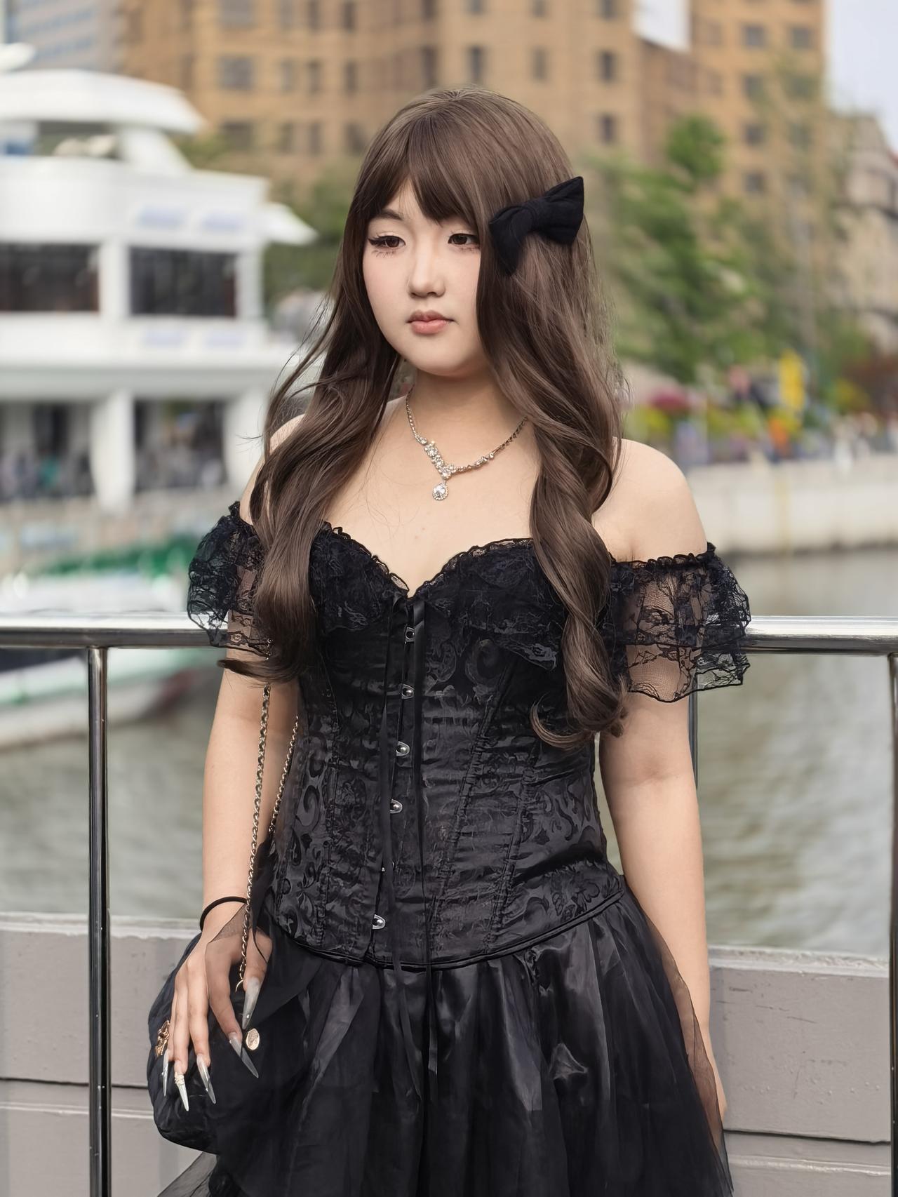 黑裙少女的街头街头的风掠过，她一身黑裙如暗夜的玫瑰，蕾丝抹胸与束腰勾勒出柔美的