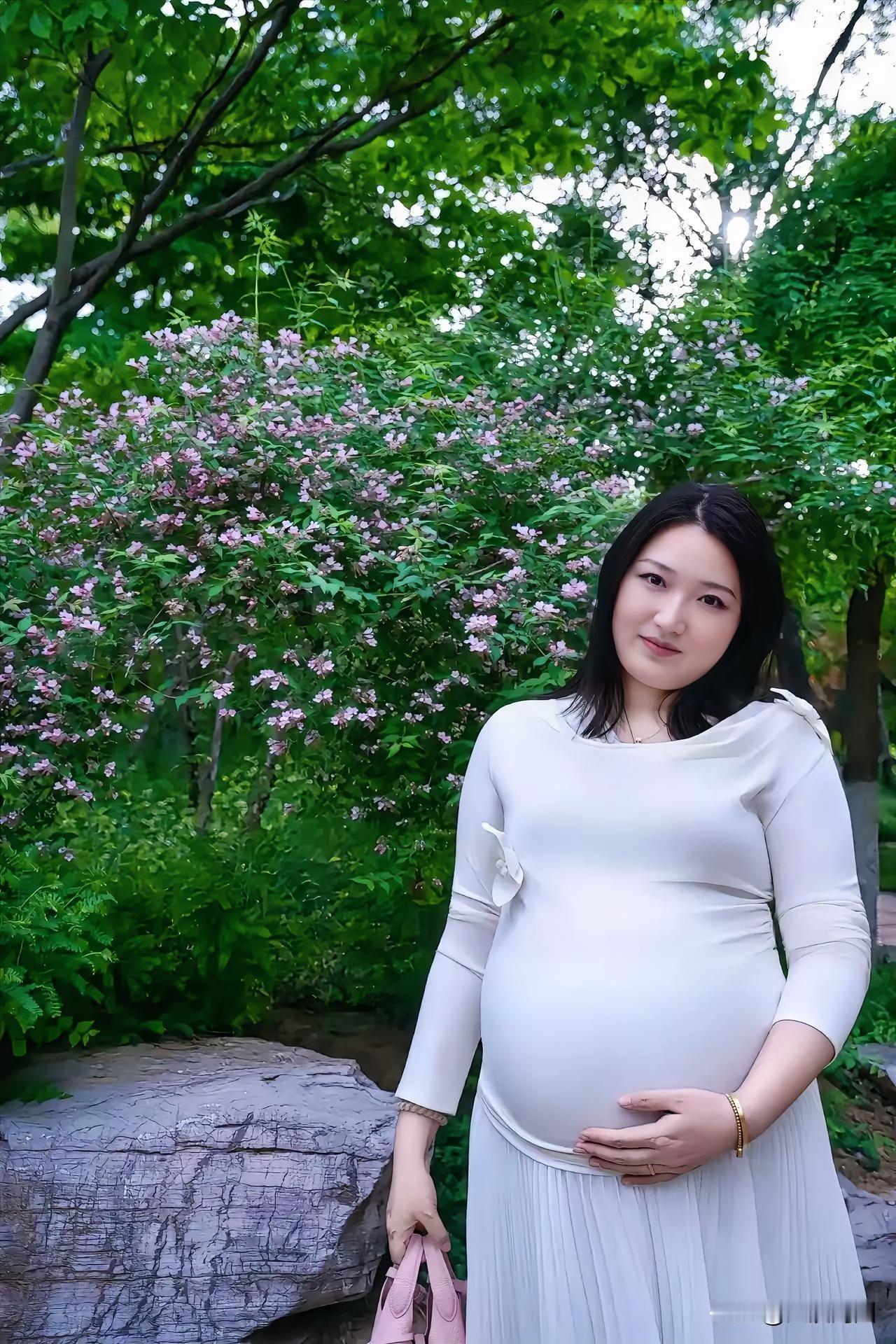 瞧这美女孕妇背靠鲜花拍的照片，简直太自然啦！怀孕背影气质孕妈照温柔系孕妇写真