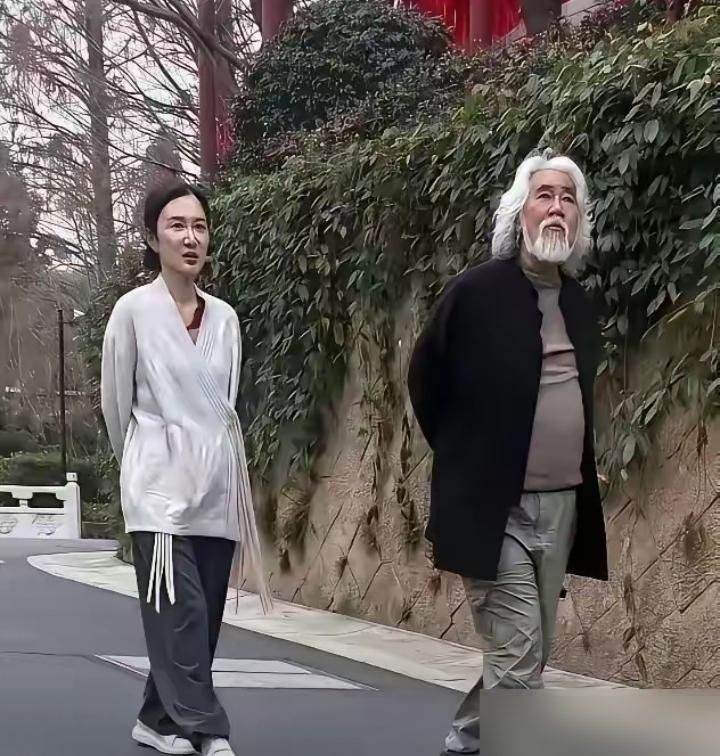 张纪中瘫在迪士尼长椅上刷手机，白胡子乱糟糟，肚子堆成两圈。旁边杜星霖低头玩自己的，中间空得能再坐个人