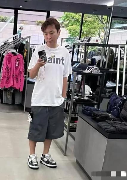 王思聪一个人在日本逛商场，时不时把玩着带有珠串的手机，短裤侧面的小玩偶与项链好抢