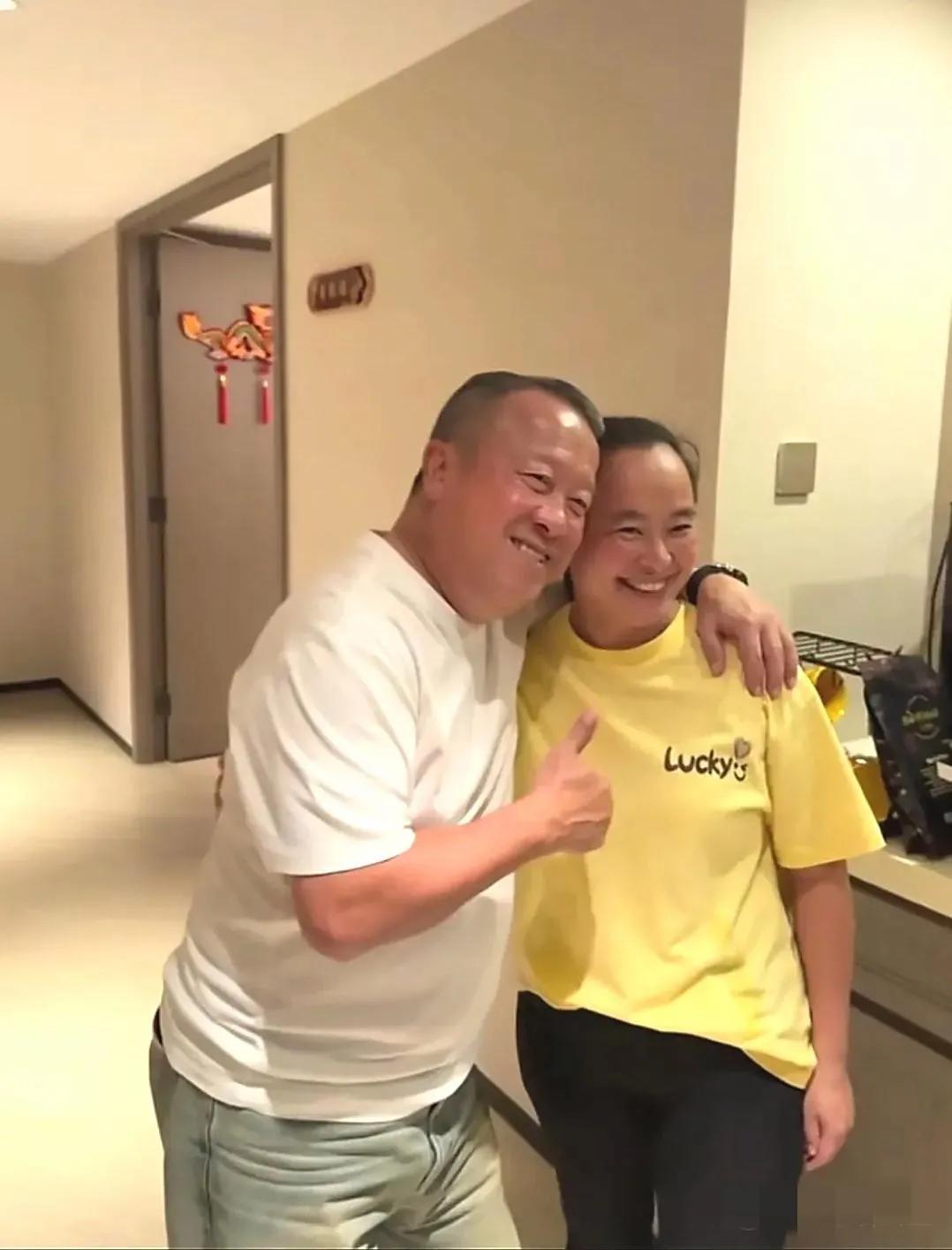 画面中的曾志伟红光满面，气色不错，眉淡额鼓，身矮腿短，笑容牵强，与女粉丝合影又是