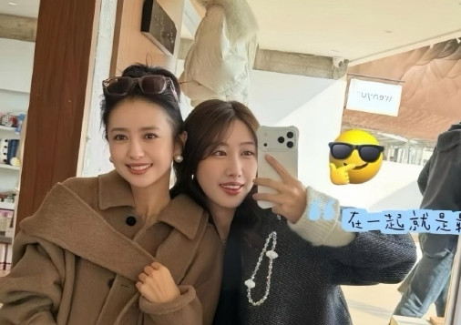 42岁的佟丽娅和好姐妹逛街，状态真好，她穿着驼色大衣，扎着丸子头，面色红润，皮肤