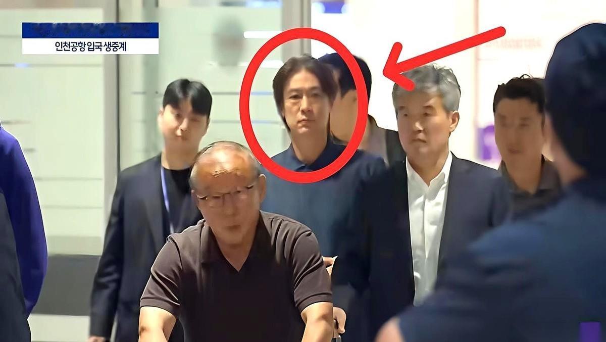 那个被围在中间、面无表情的男人，就是韩国队主帅，洪明甫。他特意选了半夜的航班，