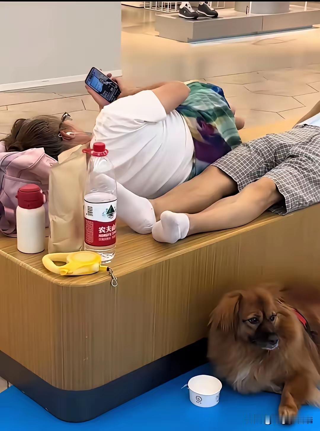 商场里的公共休息椅，一张能坐五六个人。有人把它当自家床了。一男一女，脱了