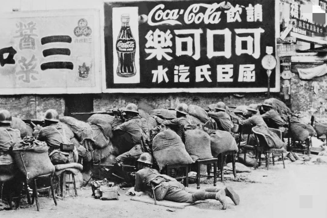 1937年淞沪会战，广告牌下的战争。图中广告牌是可口可乐和三和酱菜。从广告牌上