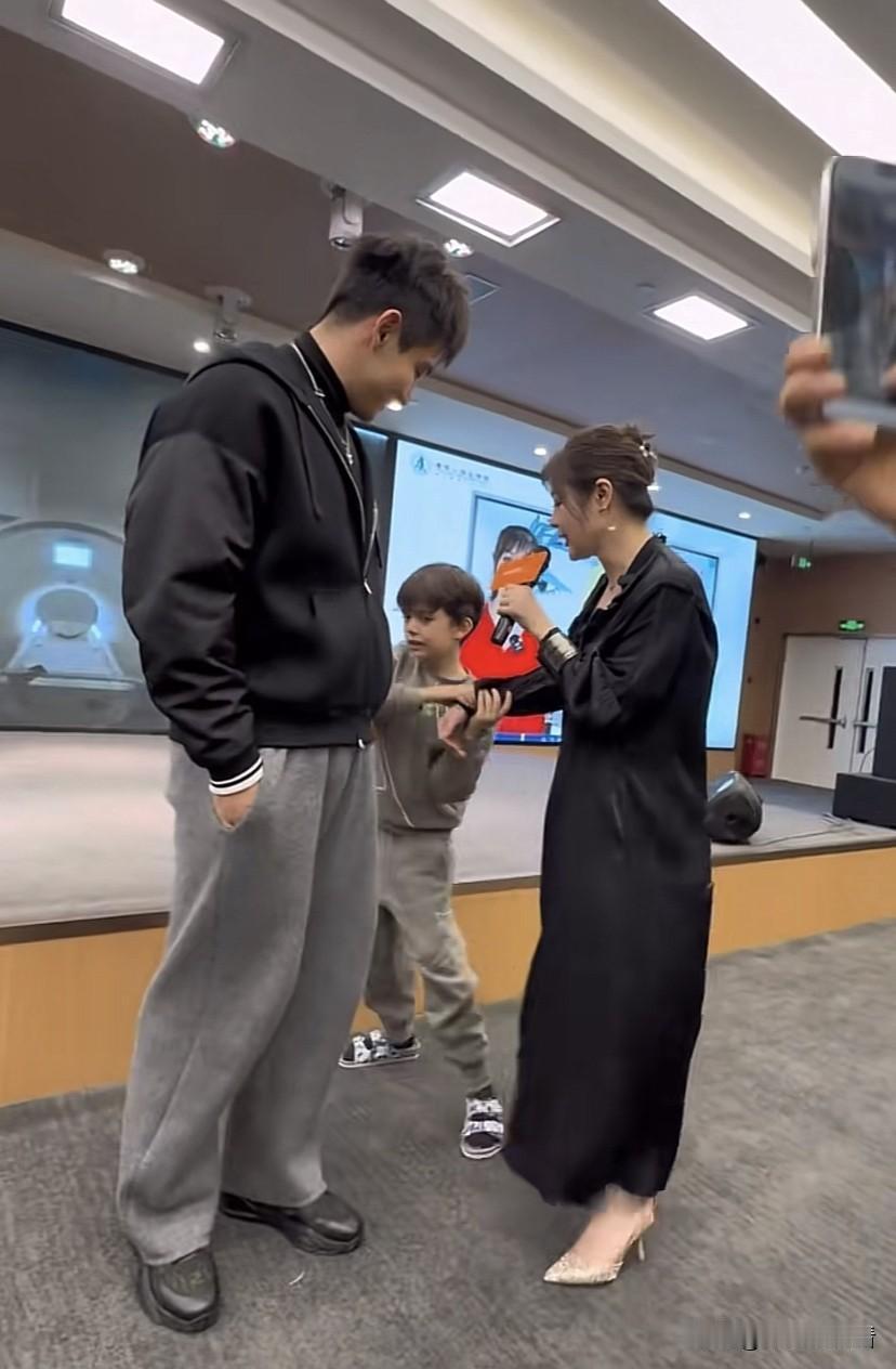 于会长家的这个小儿子挺聪明的，别看年纪小，啥也知道，妈妈台上讲话结束，准备下台的