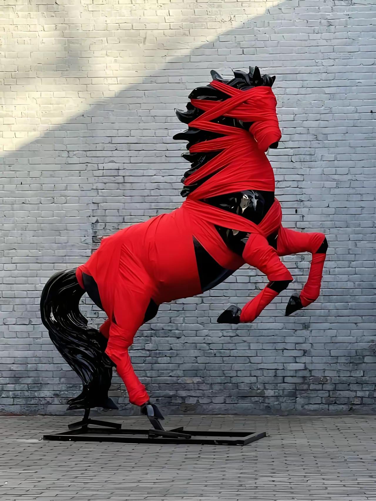 清华美院的马年新雕塑作品来了。一匹黑色的马，后蹄登地，前蹄扬起，作势奔驰，然其