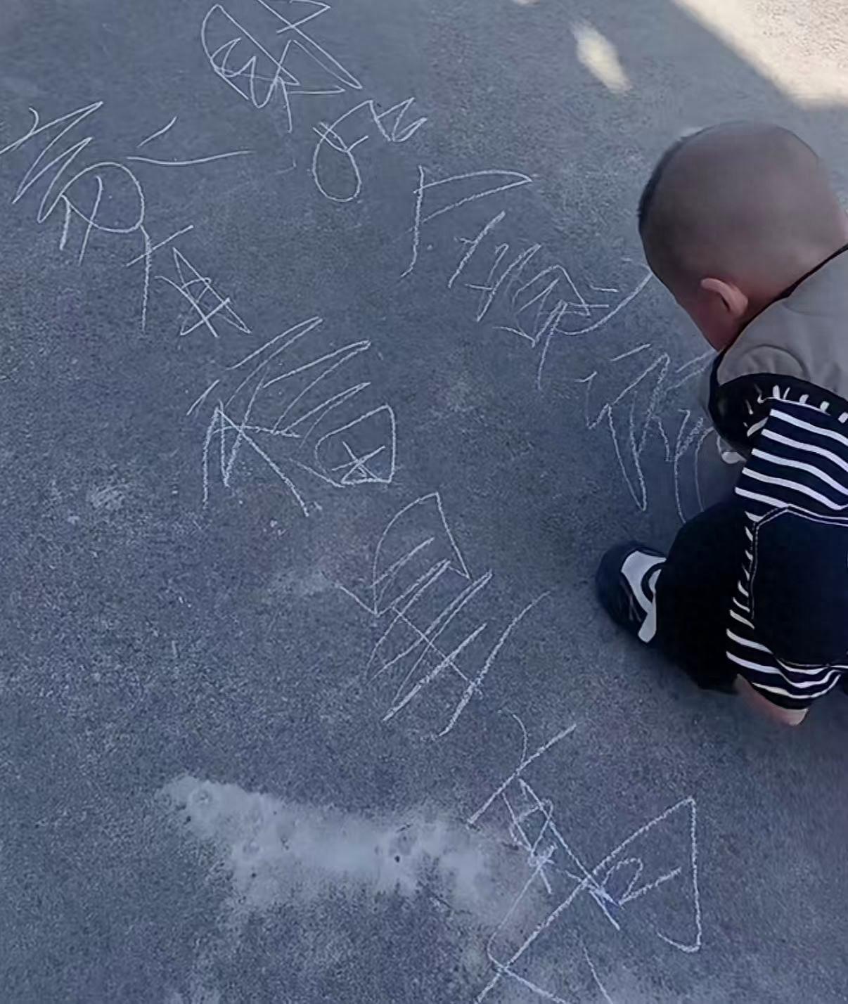 江苏苏州，一位母亲在网上晒出2岁半孩子写字的视频，结果看呆网友，拿石笔在地上写字