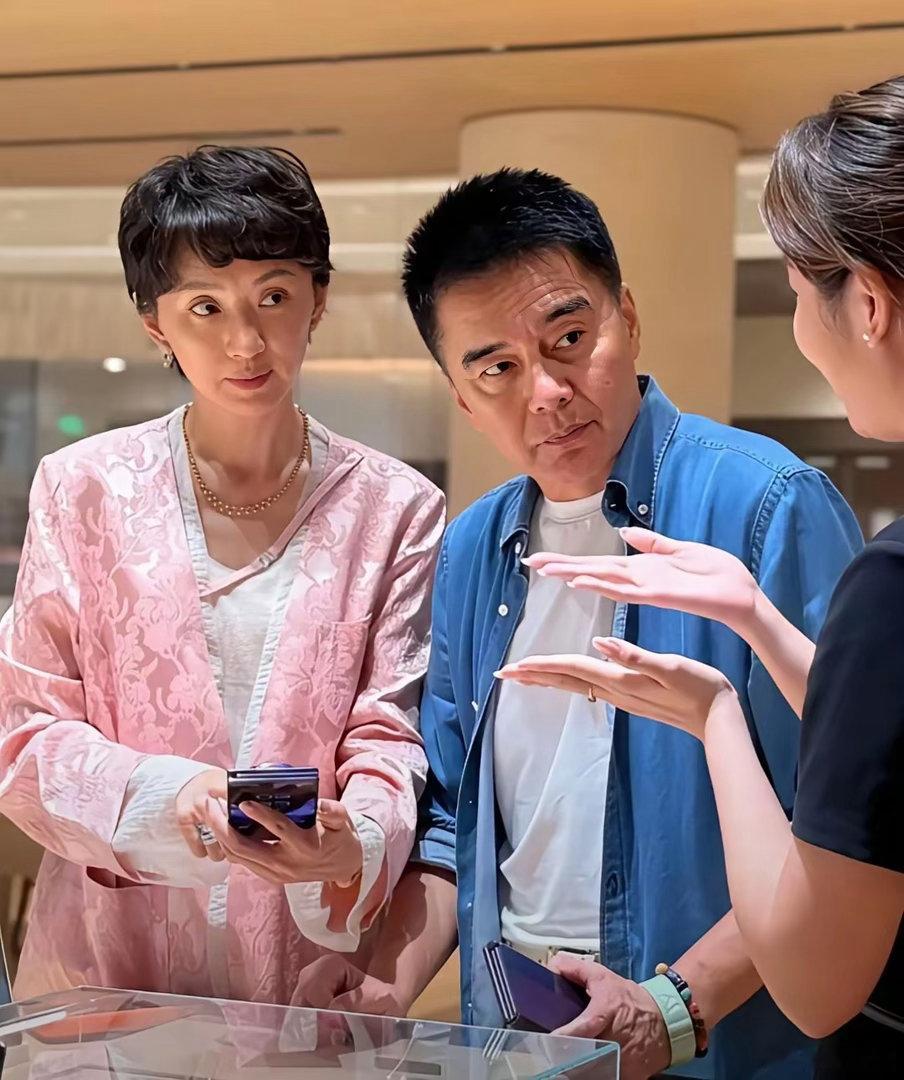 许亚军陪第三任小娇妻张澍现身手机店买手机时的一幕，店员在一旁介绍产品。​​​
