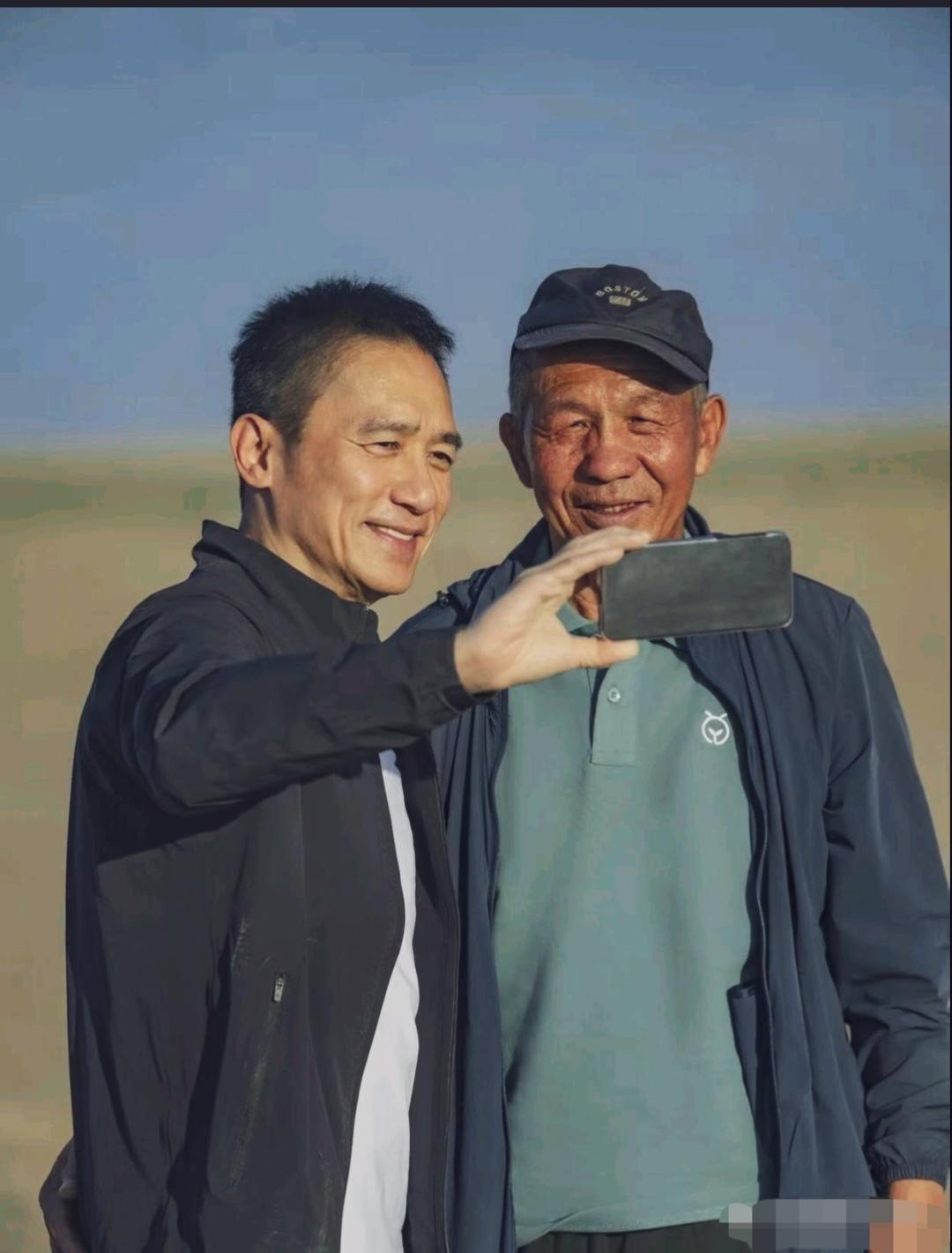 梁朝伟在敦煌沙漠参加种树的公益活动，他个子不高，不爱笑的他笑起来特别好看，性格也