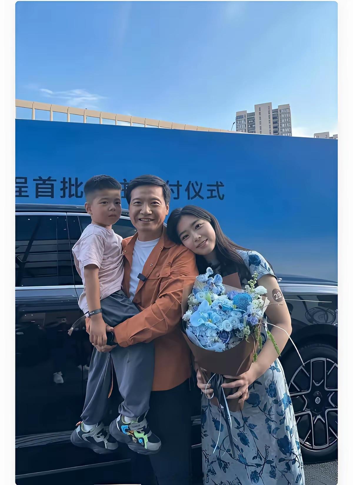 雷军亲自交车，抱着车主孩子合影，笑得像邻居大哥。不知道的还以为是一家人的合影。​