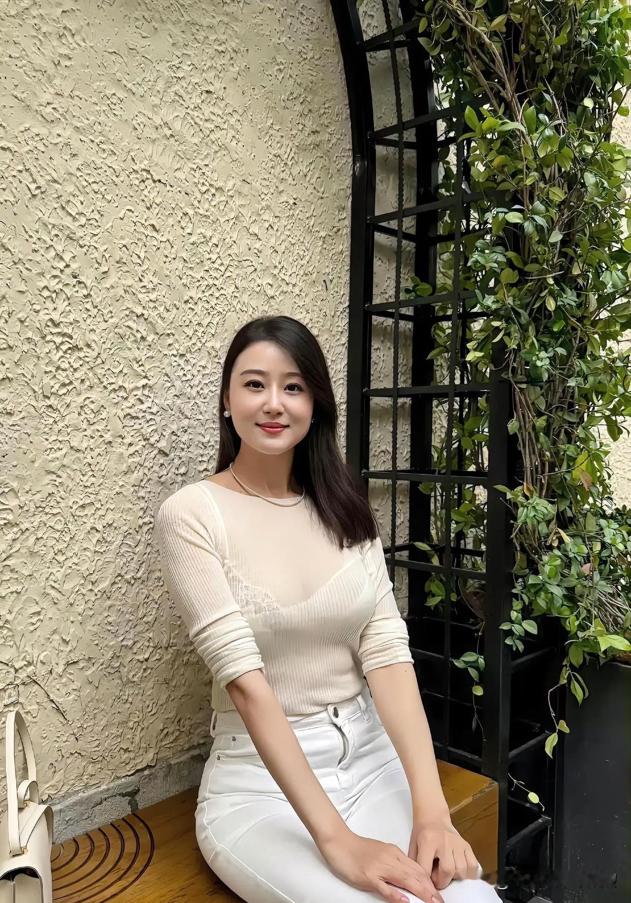 素衣胜雪倚白墙，绿植轻绕。浅笑温婉，静享时光，清新如春日微风拂面。