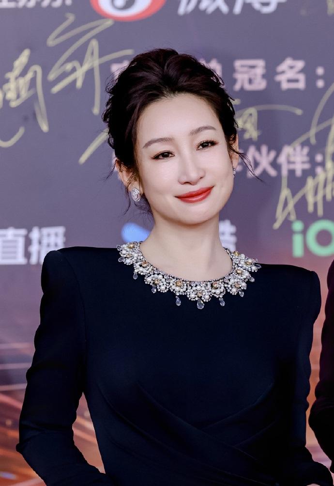 今天秦海璐在出席时尚活动的时候搭配了一件黑色的裙子，看上去特别的显年轻。秦海