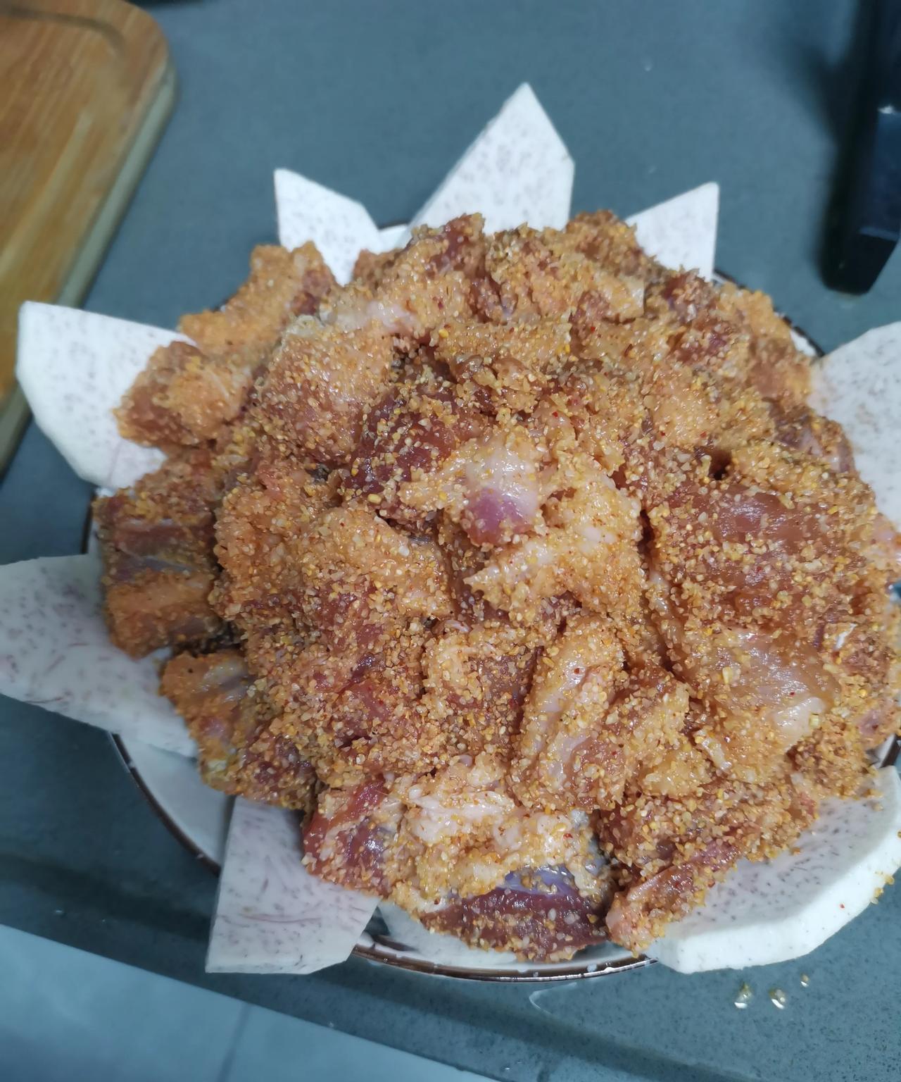 蒸米粉肉①3块钱买了个芋头，去皮切成薄片，放在盘底。②22块钱1斤的排骨买了