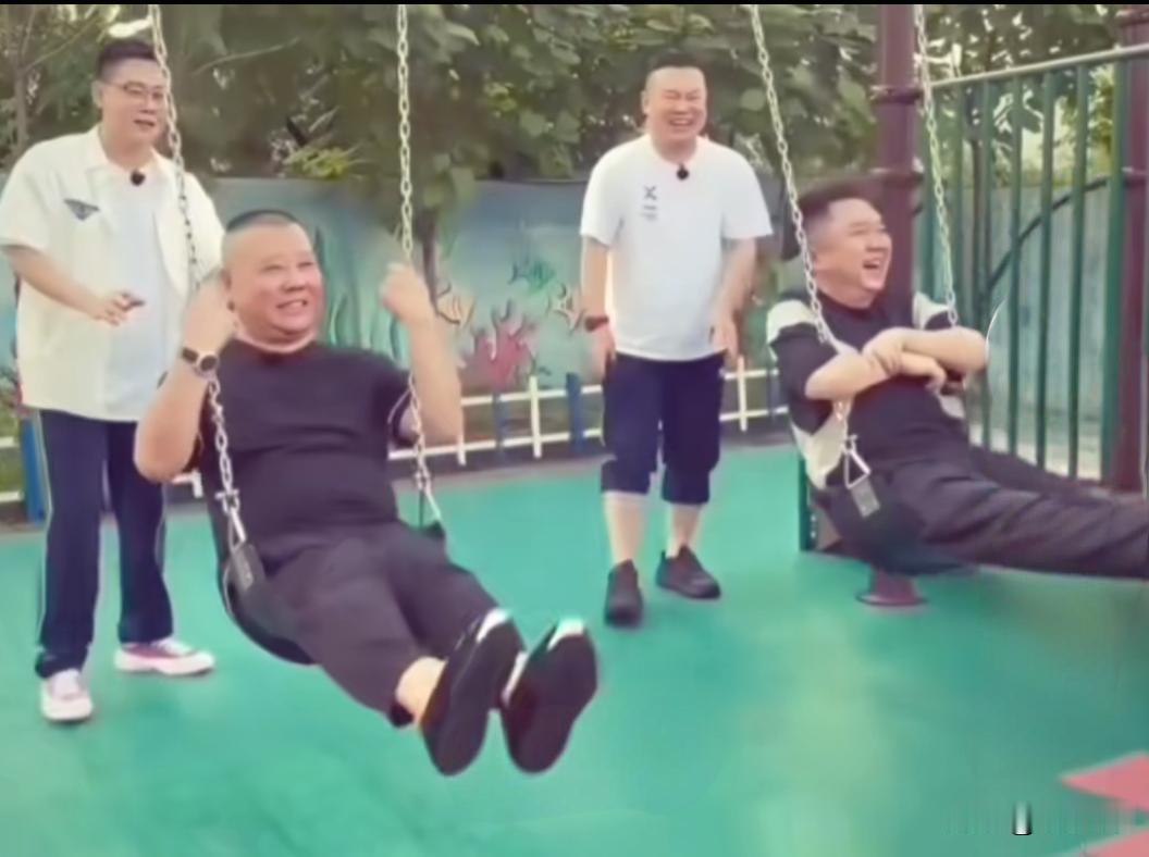郭德纲和于谦并排坐在儿童秋千上，玩的十分开心。岳云鹏、栾云平在一旁陪着说笑，师徒