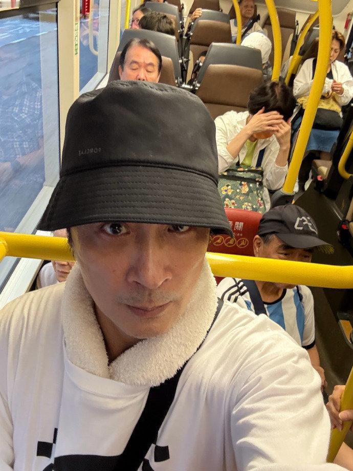 63岁的吴镇宇在乘坐公交时使用老年卡，因外貌显年轻被司机质疑并险些被赶下车，他当