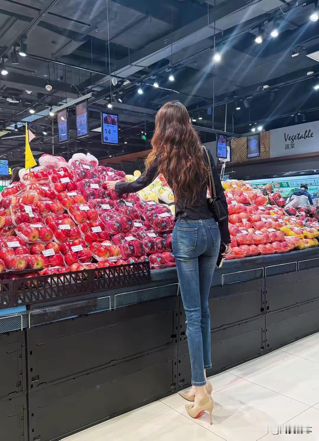 在琳琅满目的水果区挑选新鲜苹果，享受购物的乐趣！🍎