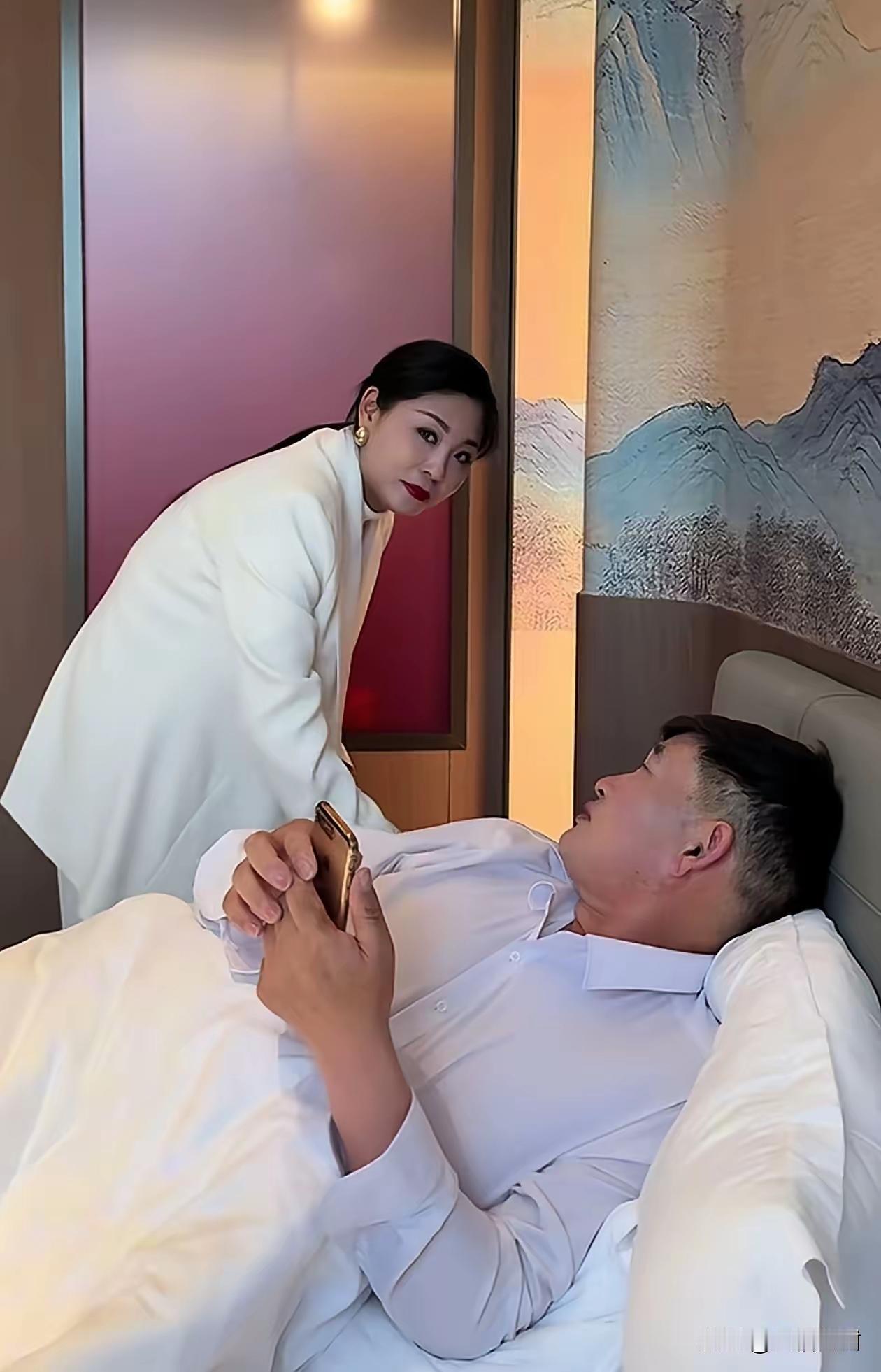 相信大衣哥的人品，这样的视频不可信大衣哥躺在床上，一个年轻的女子站在床头充电，