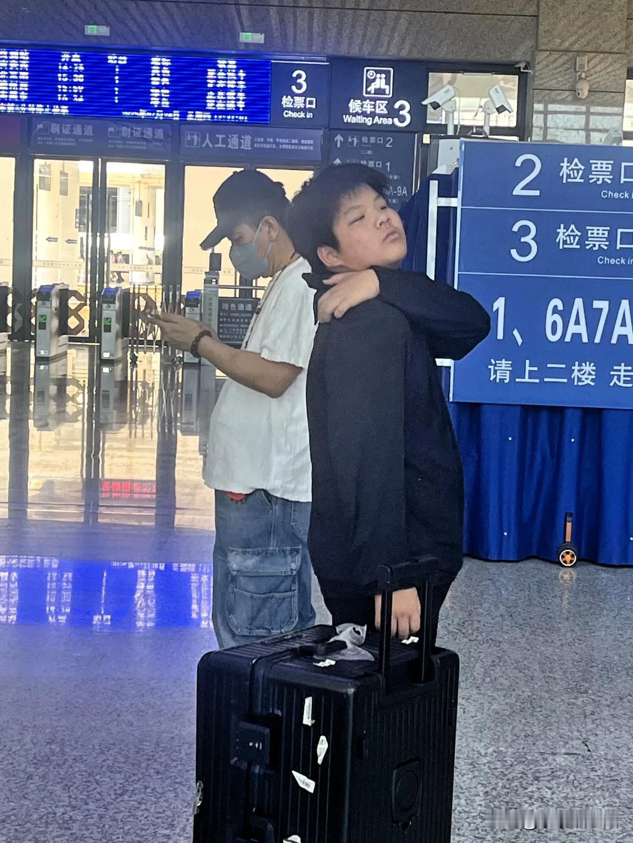 杨子带着儿子安迪在景德北站候机！父子俩各忙各的！安迪无聊的抓着痒，杨子在一旁低头