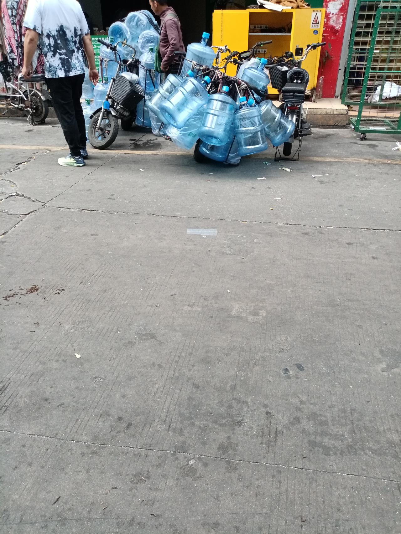 广州城中村的送水工，一台小小电动车，拉着十几桶水，重达几百斤，这大叔年纪这么大了