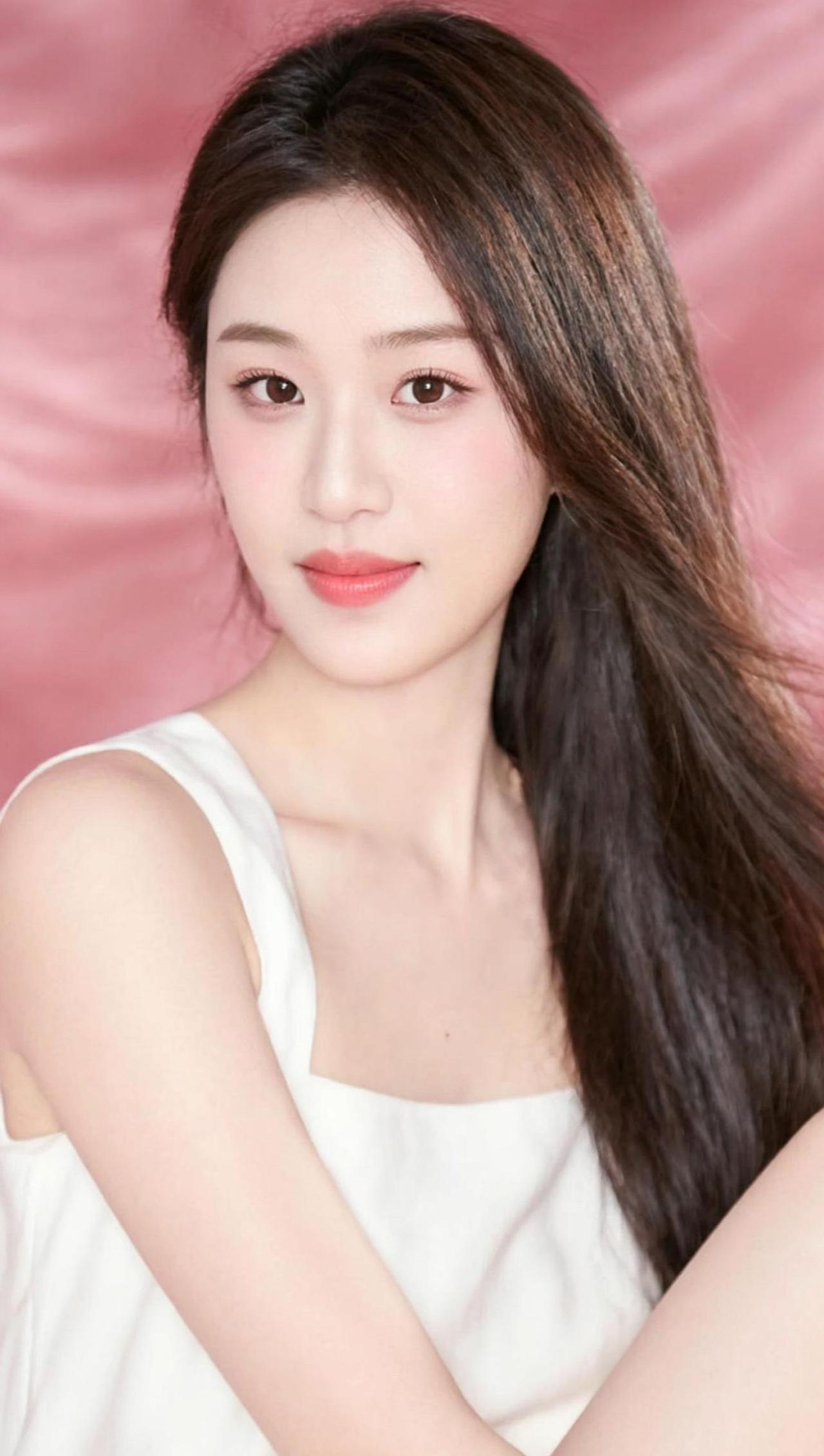 在柔和的灯光下，长发如瀑布般倾泻而下，映衬出一种静谧的美。背景的朦胧色彩仿佛为这