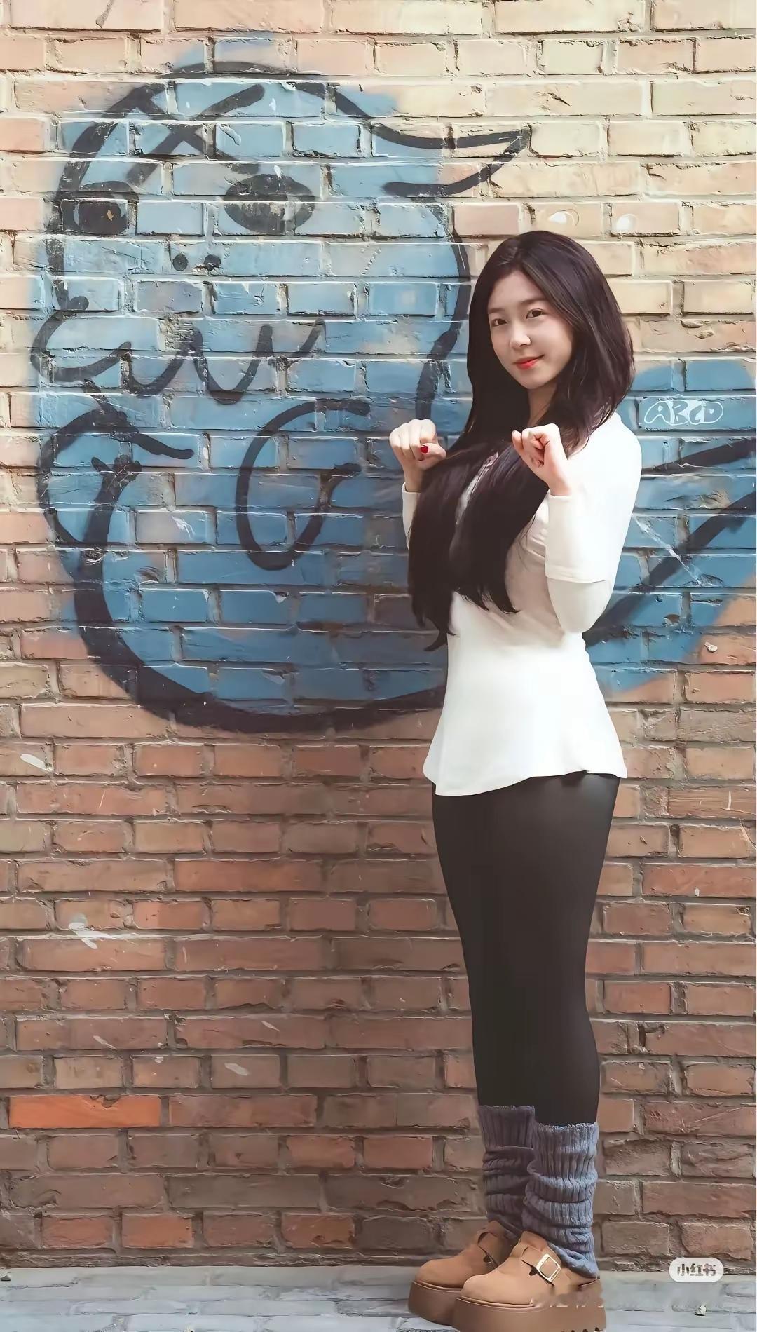 红砖墙前，白衣少女，黑发飘逸，微笑如花。