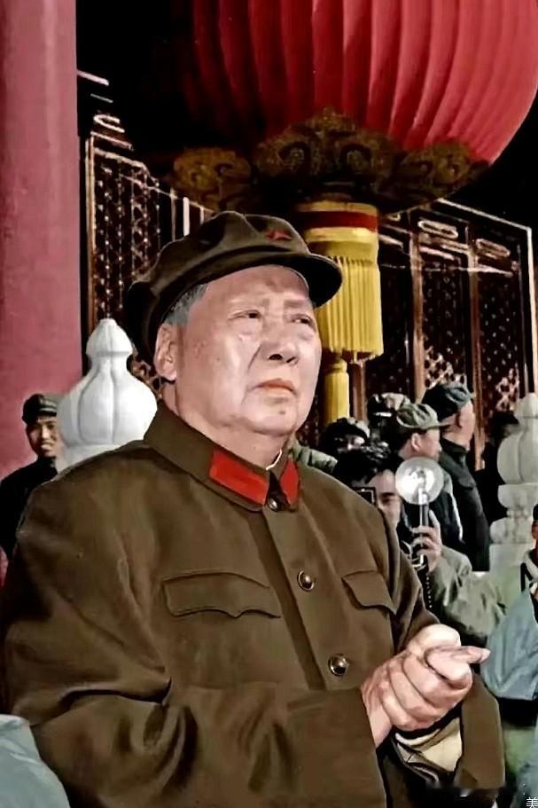 这是六十年代毛主席穿着军装拍摄的照片。毛主席站在天安门城楼上，紧紧地扣着大手