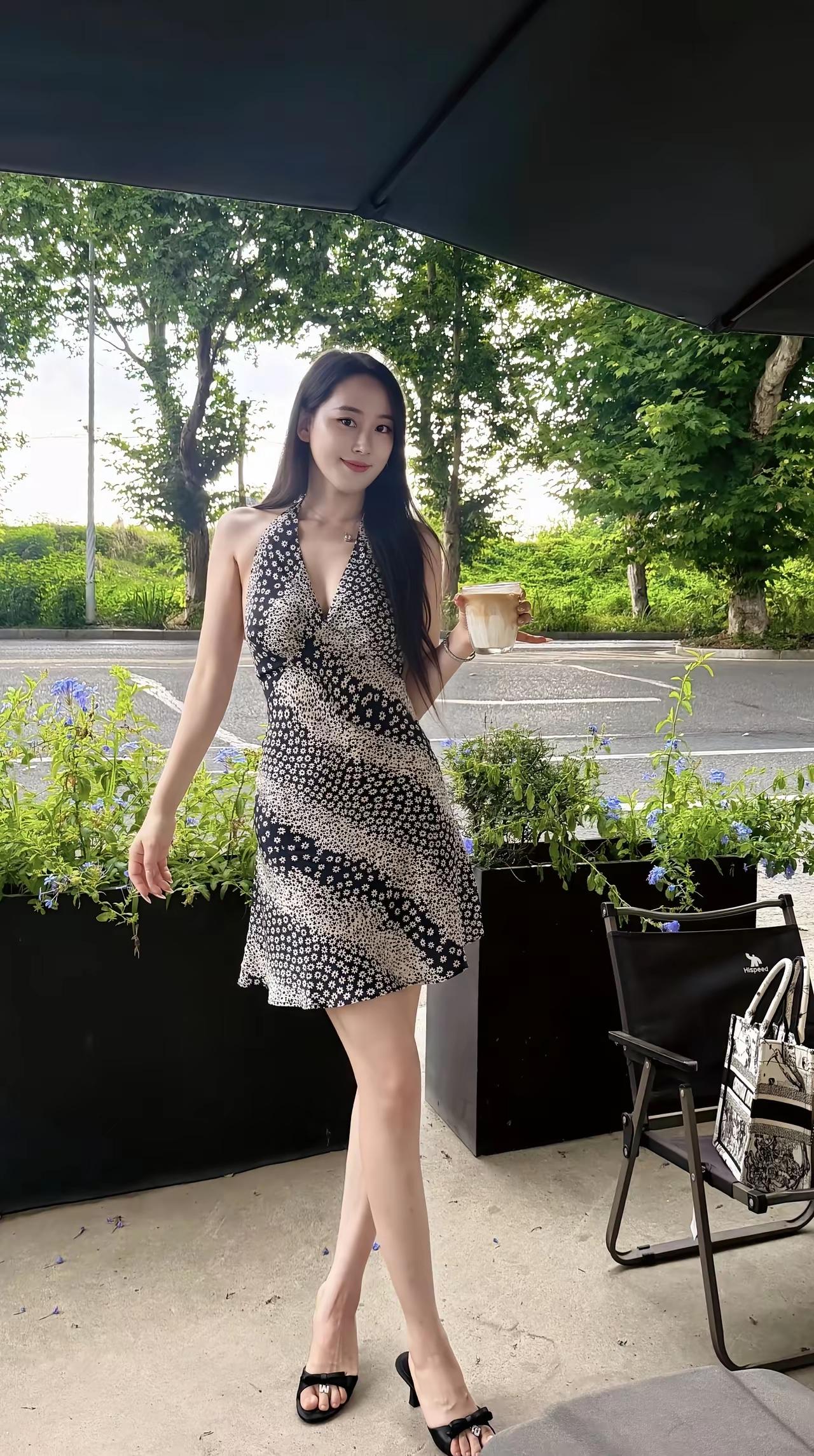 一位美女在户外喝咖啡。