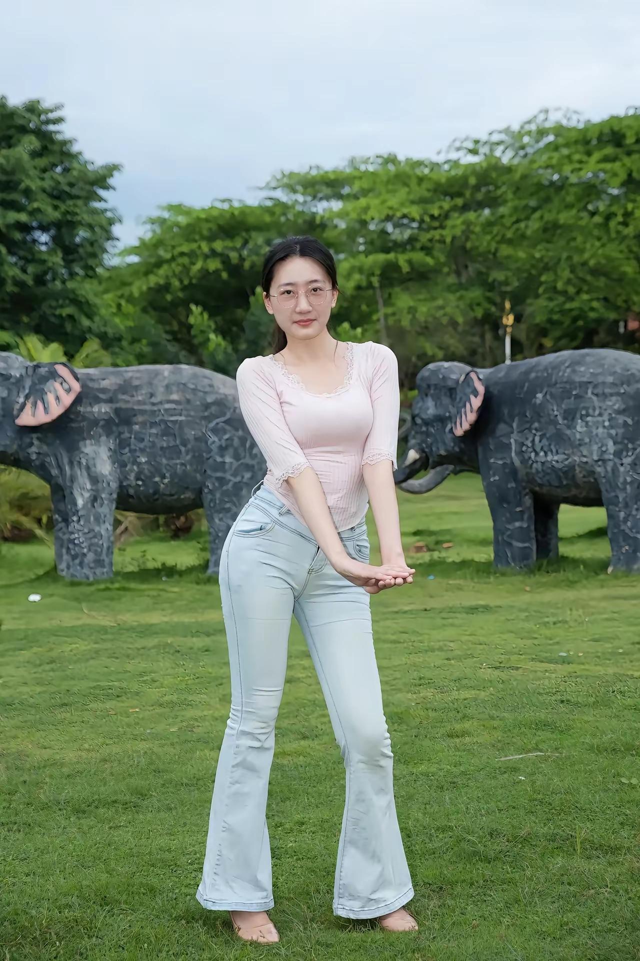 在绿意盎然的草地上，与大象雕塑合影，轻松自在的一天。🌿🐘😊