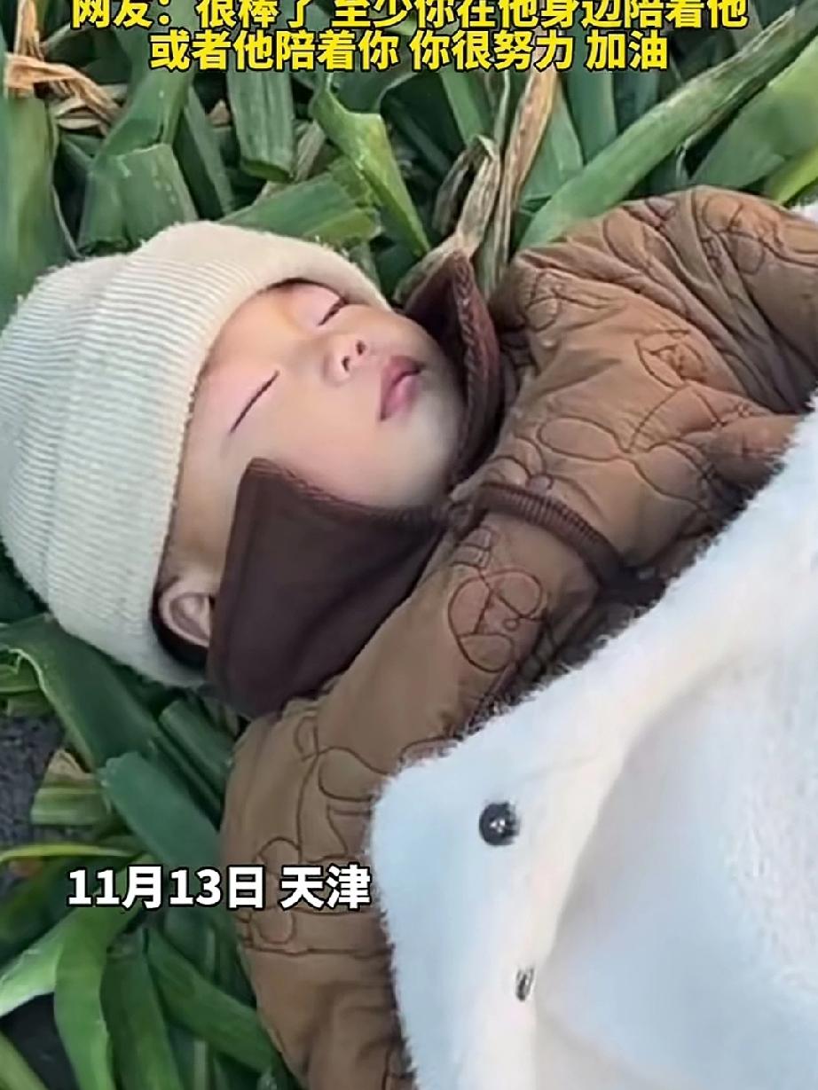 妈妈带着孩子摆摊卖葱，无奈让睡着的孩子躺在了大葱叶上，妈妈忙于买卖，已顾不得抱着