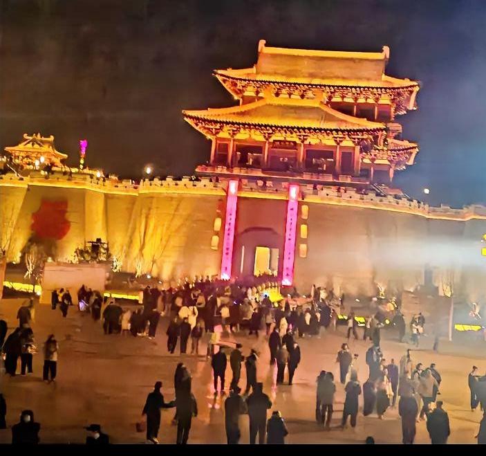 老乡们，晚上好啊！你看咱新密溱洧水城这夜景，城楼亮堂堂，人挤人热闹得很！这可