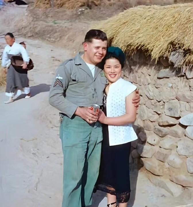1959年，汉城。一名美军一只手紧紧地搂着一名韩国妇女，另一手拿着一罐啤酒，而韩