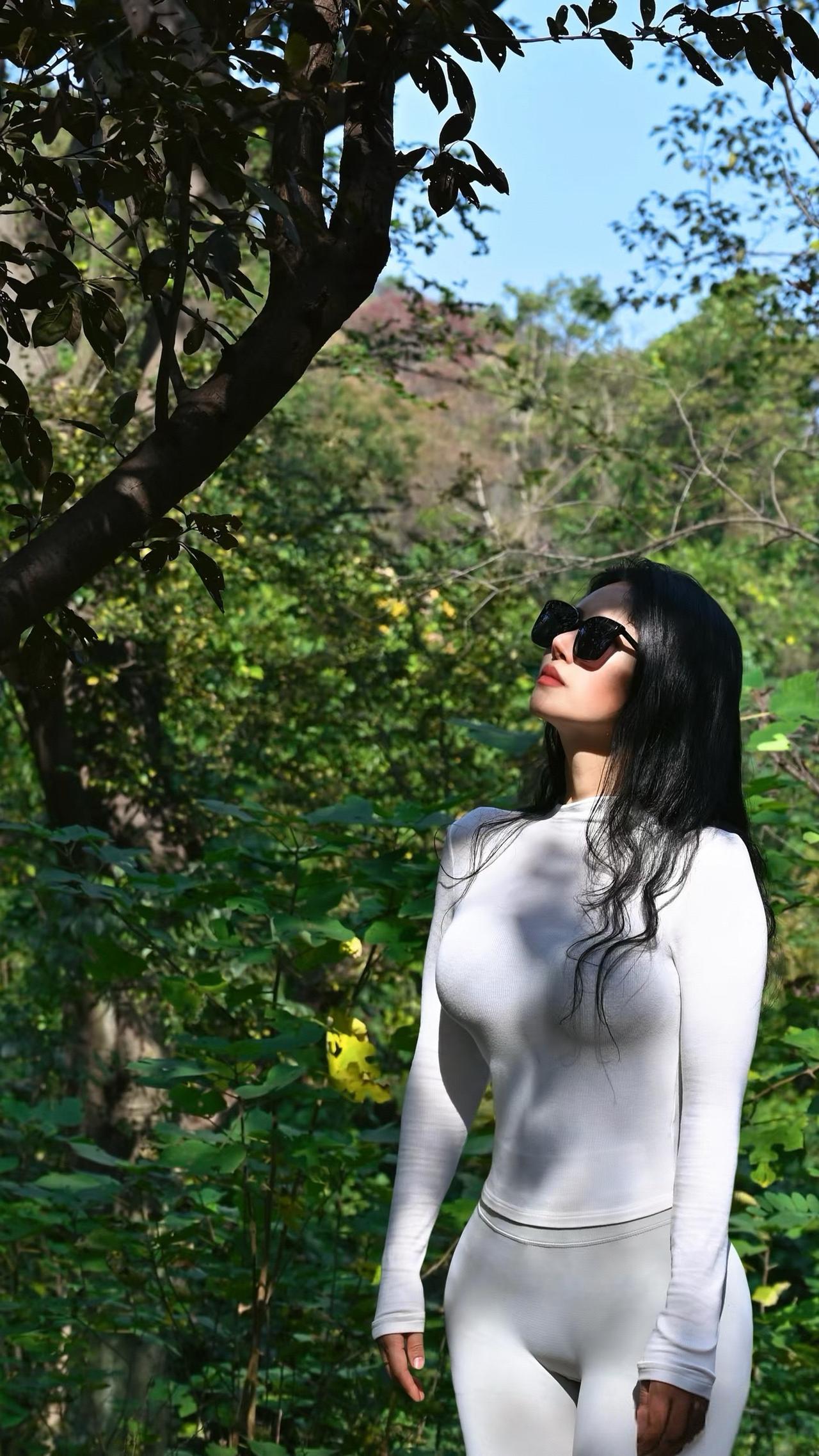 黑发飘逸，墨镜遮面，自然中的时尚