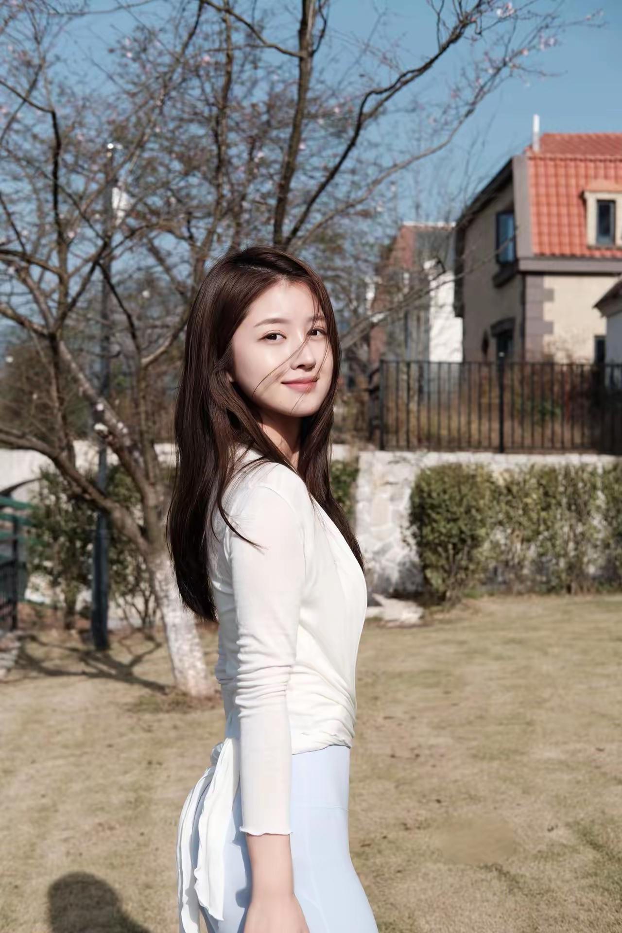 阳光明媚，女孩在草地上微笑。