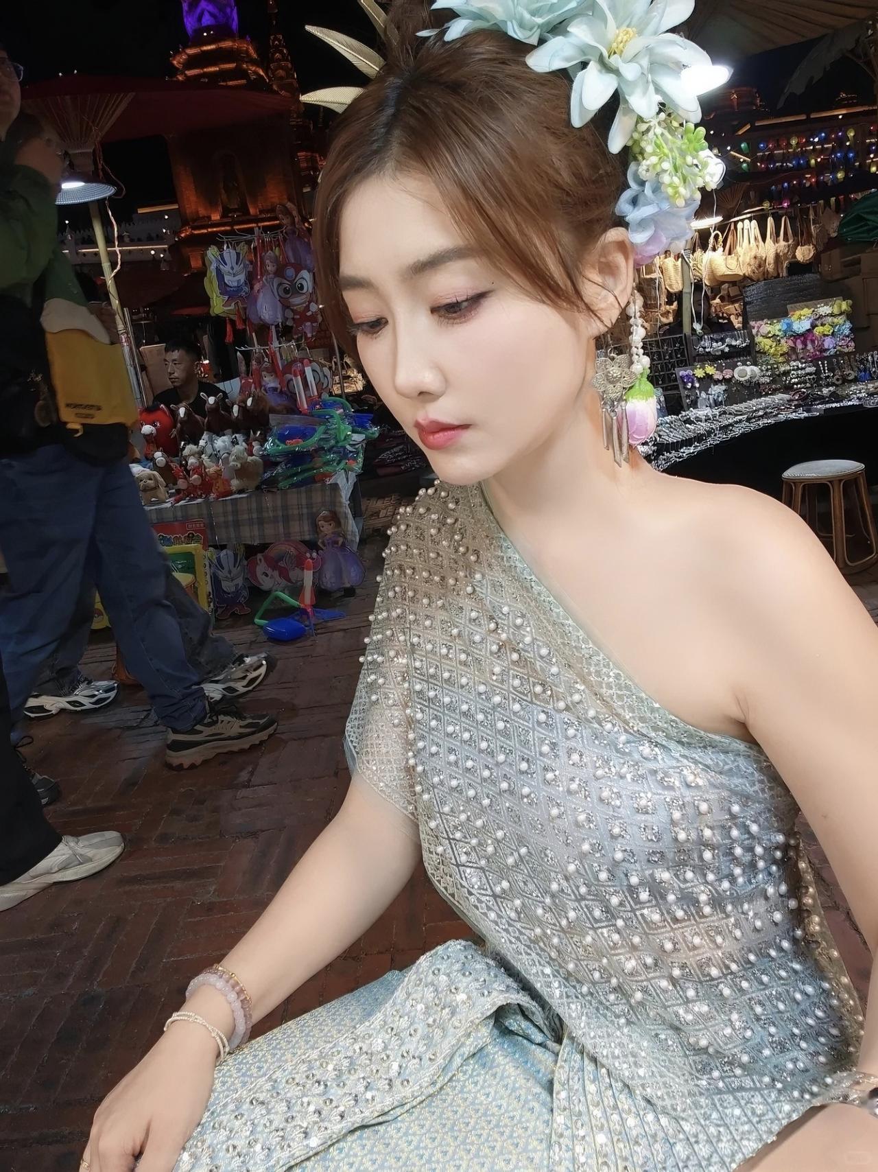 在泰国夜市解锁泰式盛装体验啦✨浅薄荷绿的泰服缀满珍珠和碎钻，在夜市暖光里闪着温