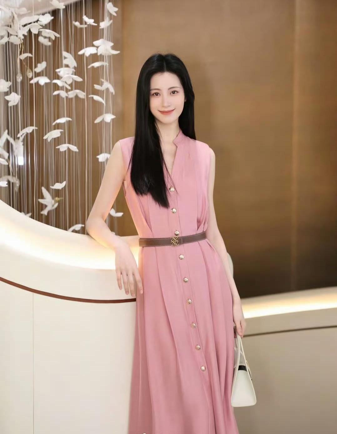 柔粉色连衣裙像把春日的甜意裹在身上，腰带一收，把身段衬得恰到好处。米白手袋和裸色