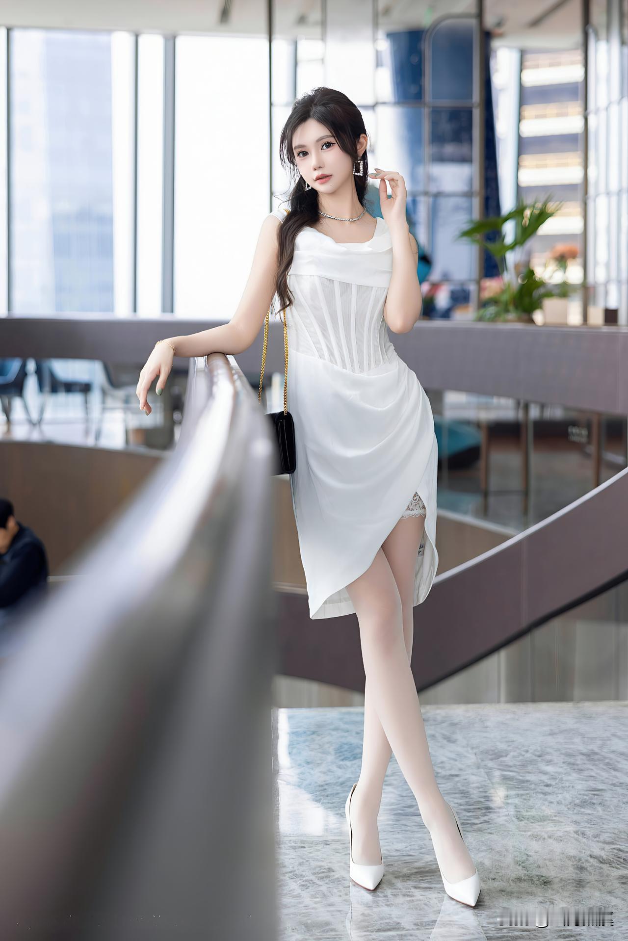 白色束腰裙勾勒出曼妙的腰肢曲线，开叉设计藏着蕾丝的温柔小心机，白丝衬得腿部线条愈