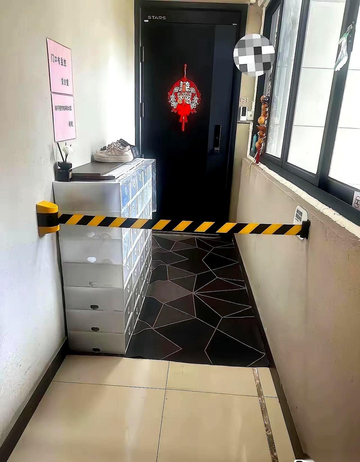 电梯门一开，走廊正中间赫然拉起了一道黄黑相间的隔离警示带。警示带后头，一组大鞋