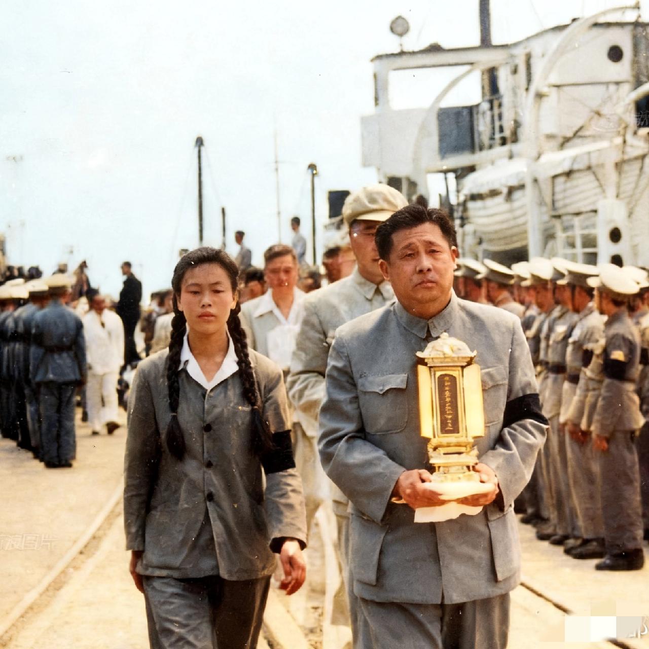 1953年，廖承志手里捧着灵位，参加抗抗日烈士遗骨运回祖国的仪式，一张罕见的留影