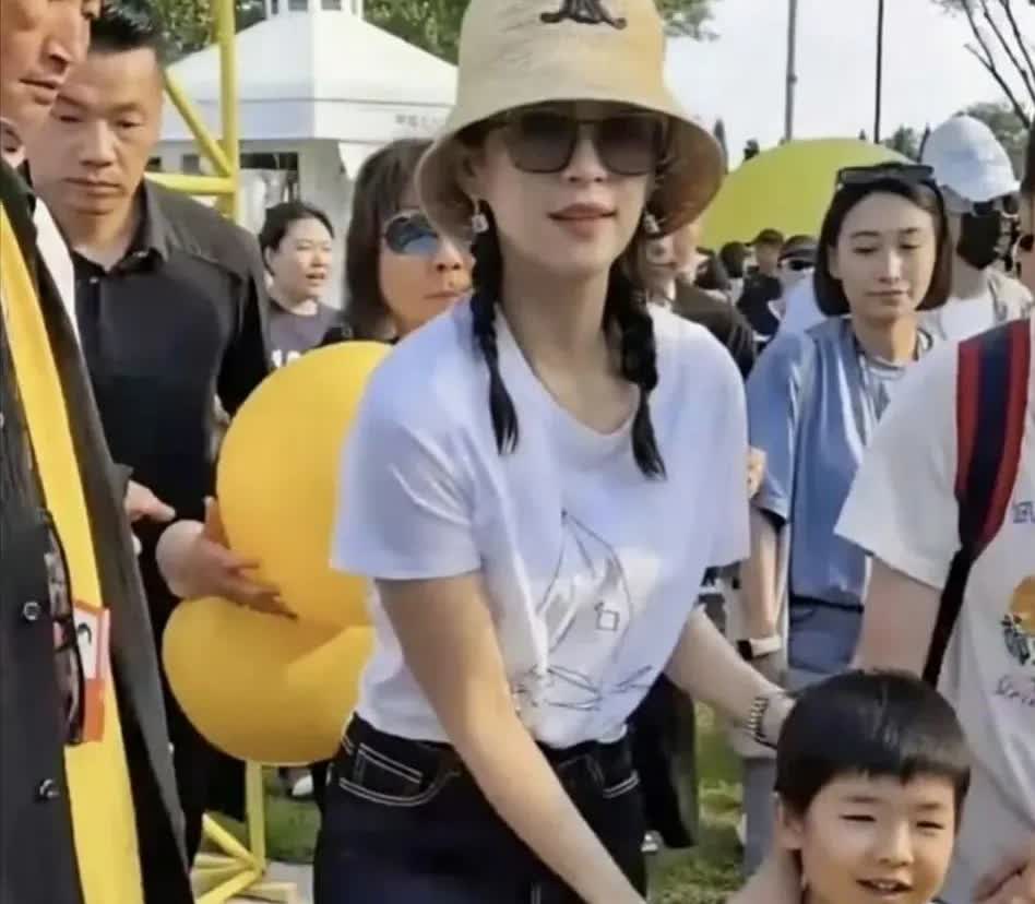 章子怡带着4岁的儿子去参加活动，特别大方呢，都没有给儿子遮挡脸部。那小家伙的模样