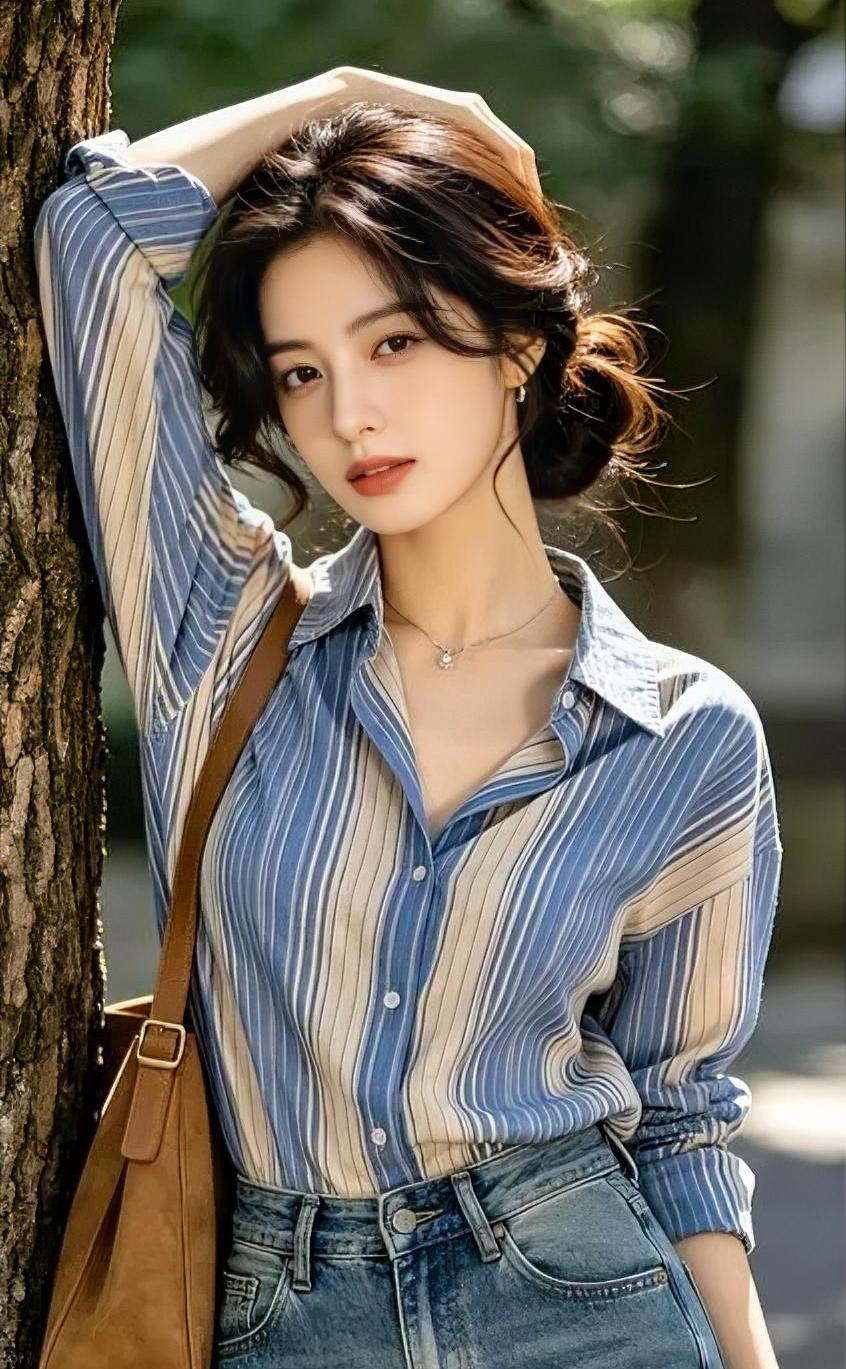 阳光穿过树叶，在蓝白条纹衫上跳跃，牛仔裤搭配棕包，透着随性的美好。你轻倚