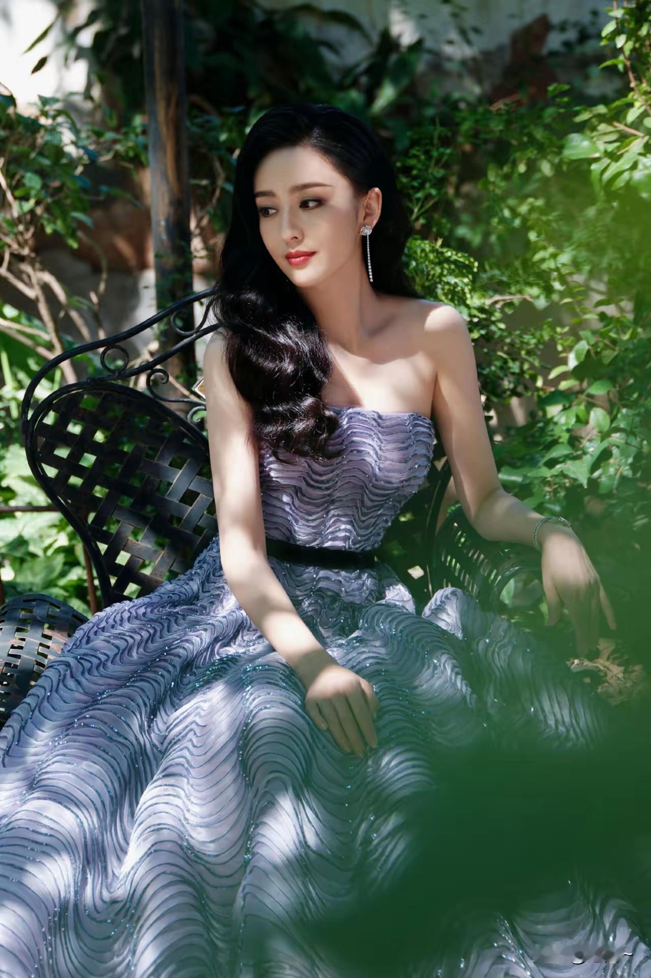 优雅黑发美人，绿意中静坐，宛如画中仙。