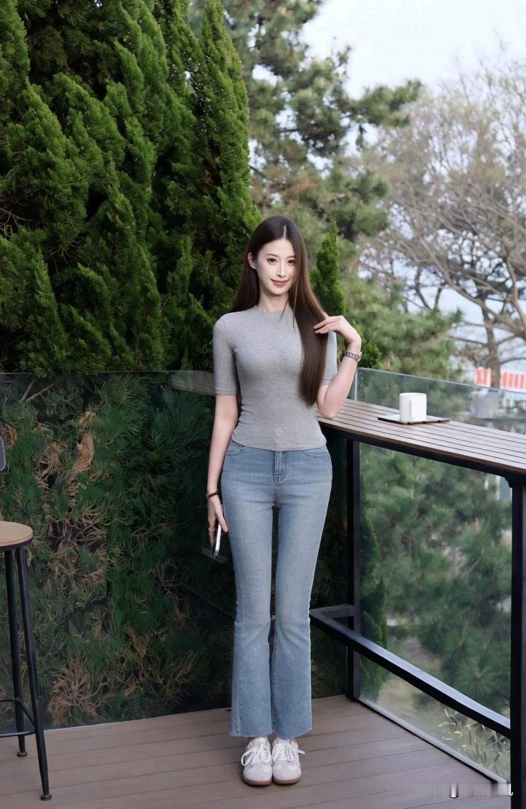 前两天上街，碰见一个姑娘在拍照片。她穿了一件灰T恤和牛仔裤，就是很普通的打扮