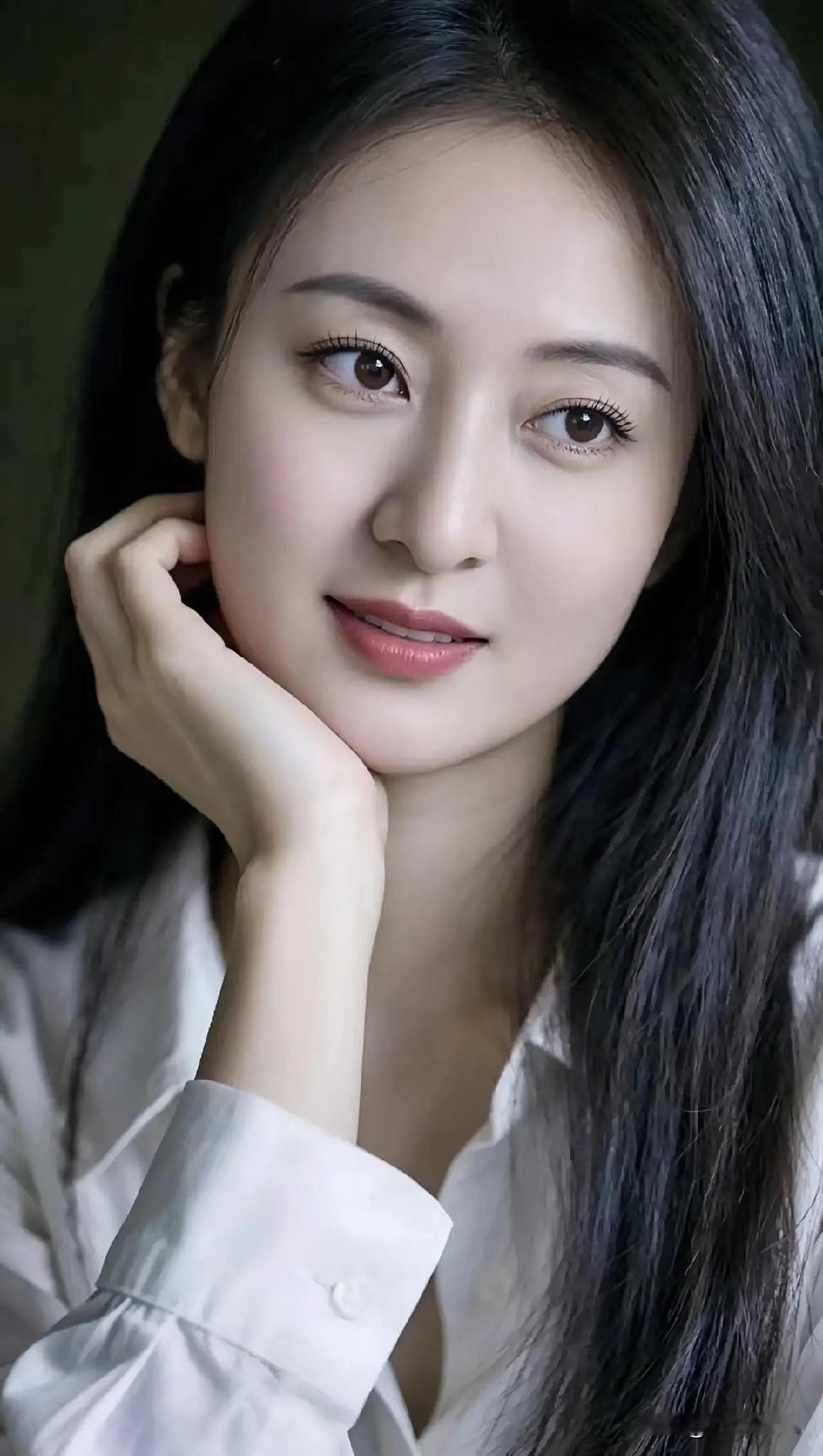 白衬衫洇着月光，她倚着静谧的夜。长发如墨瀑，垂落温柔的浪。指尖轻托腮边，