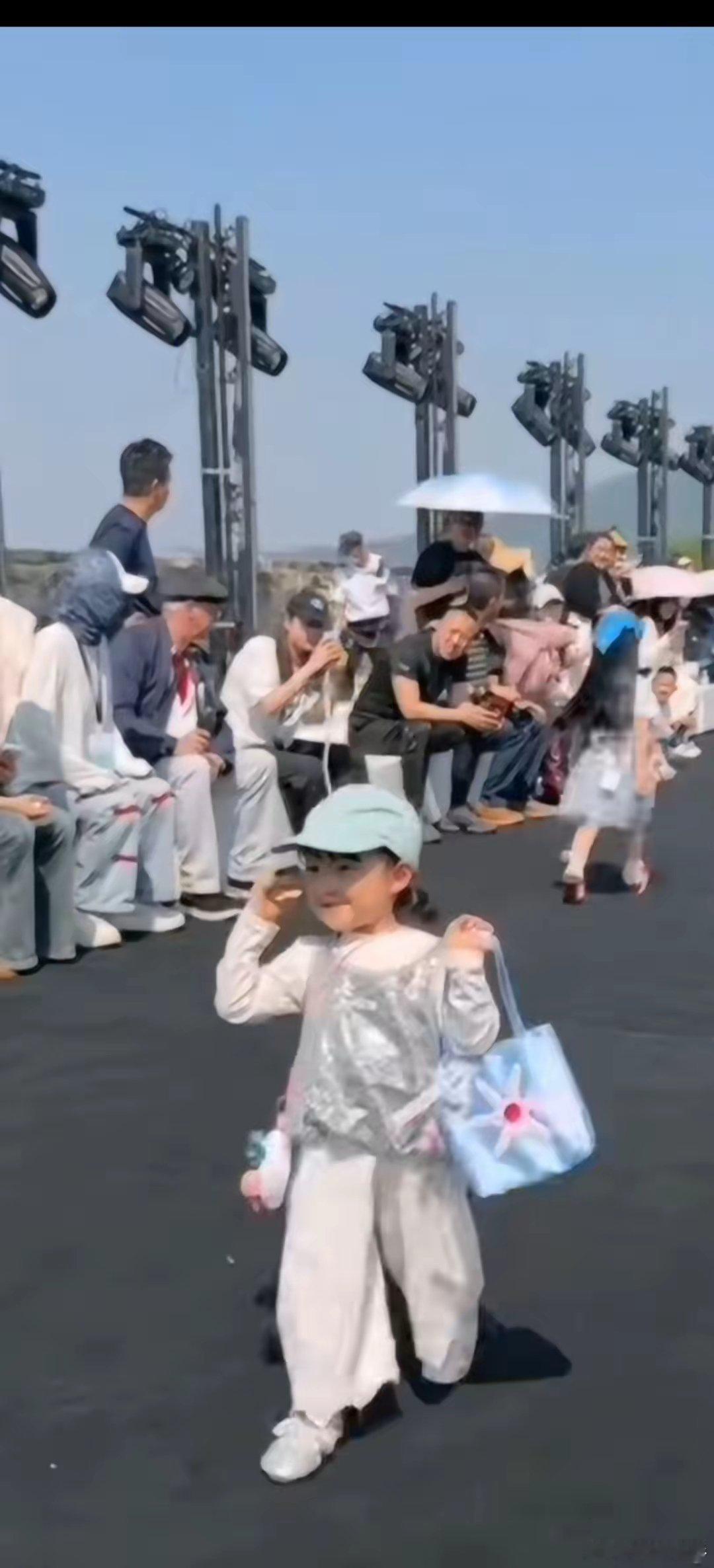 闪闪在中国国际时装周大放异彩，面对镜头，从容淡定，她带着遮阳帽，拎着挎包，走在时