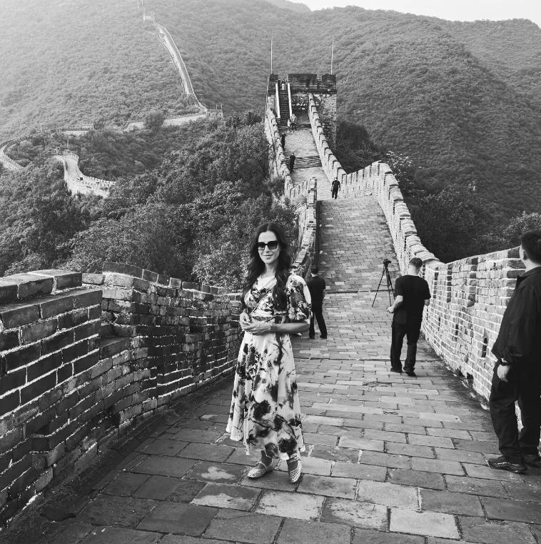 高清镜头下的塞尔维亚夫人爬长城！她站在长城上，身后是一望无际的长城，尽管是黑白大