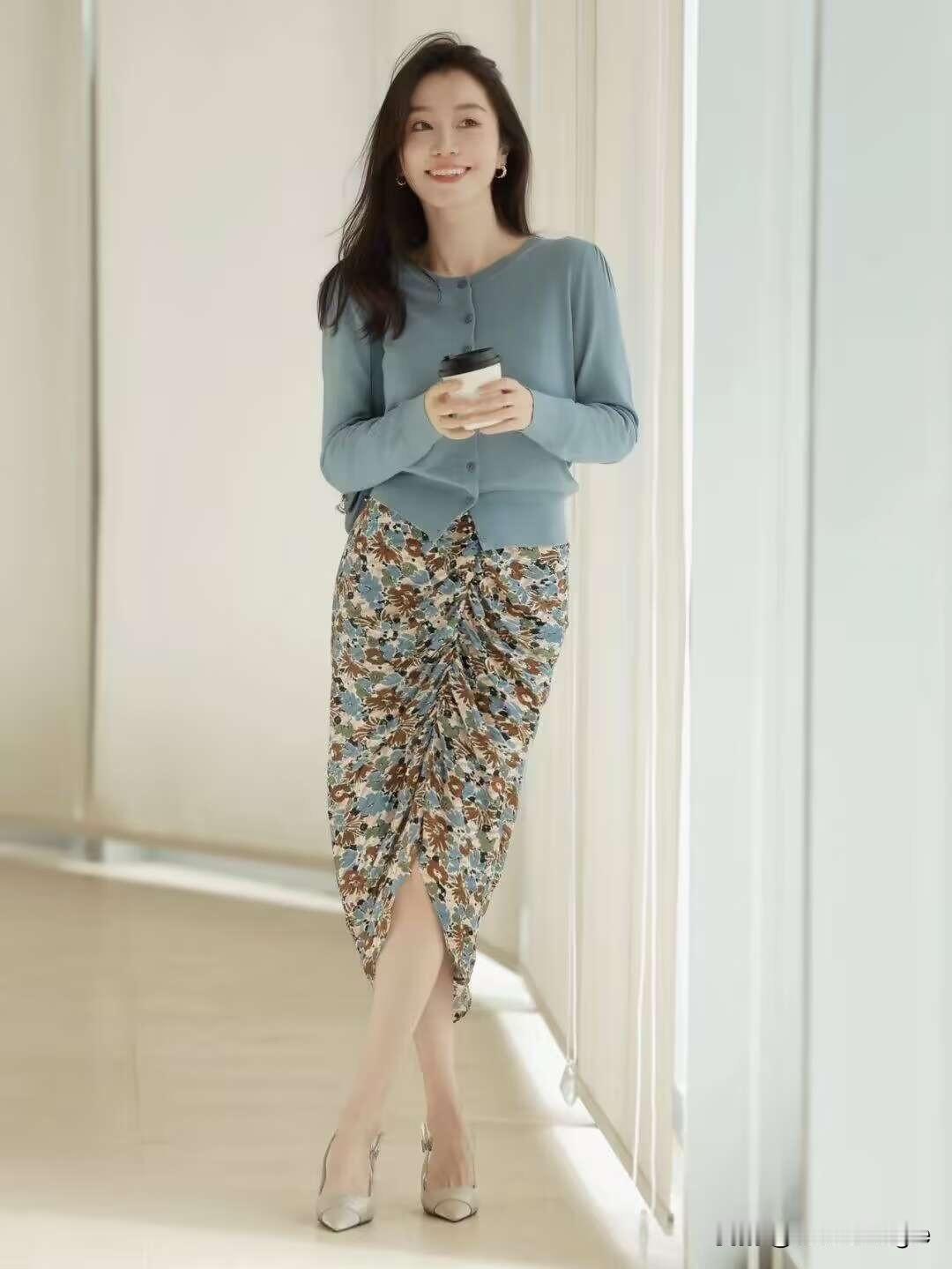 一个漂亮姑娘坐在长椅上，喝着咖啡。